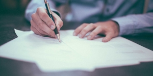 man signing document
