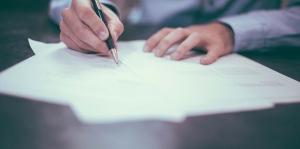 man signing documents