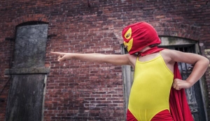 child in costume with mask and cape