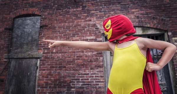 child in costume with mask and cape