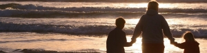 mom with kids looking at the ocean