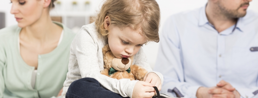 little girl hugging teddy bear