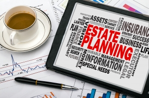 An Estate Planning word graphic, a cup of coffee, and a pen on top of charts and graphs